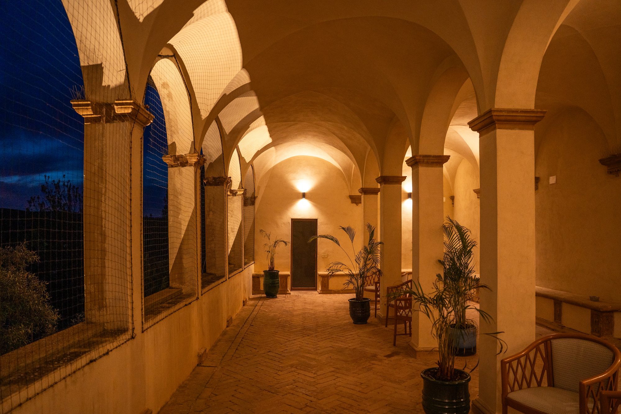 La loggia del primo piano di Volte Alte all'ora blu, con gli archi sulle colline