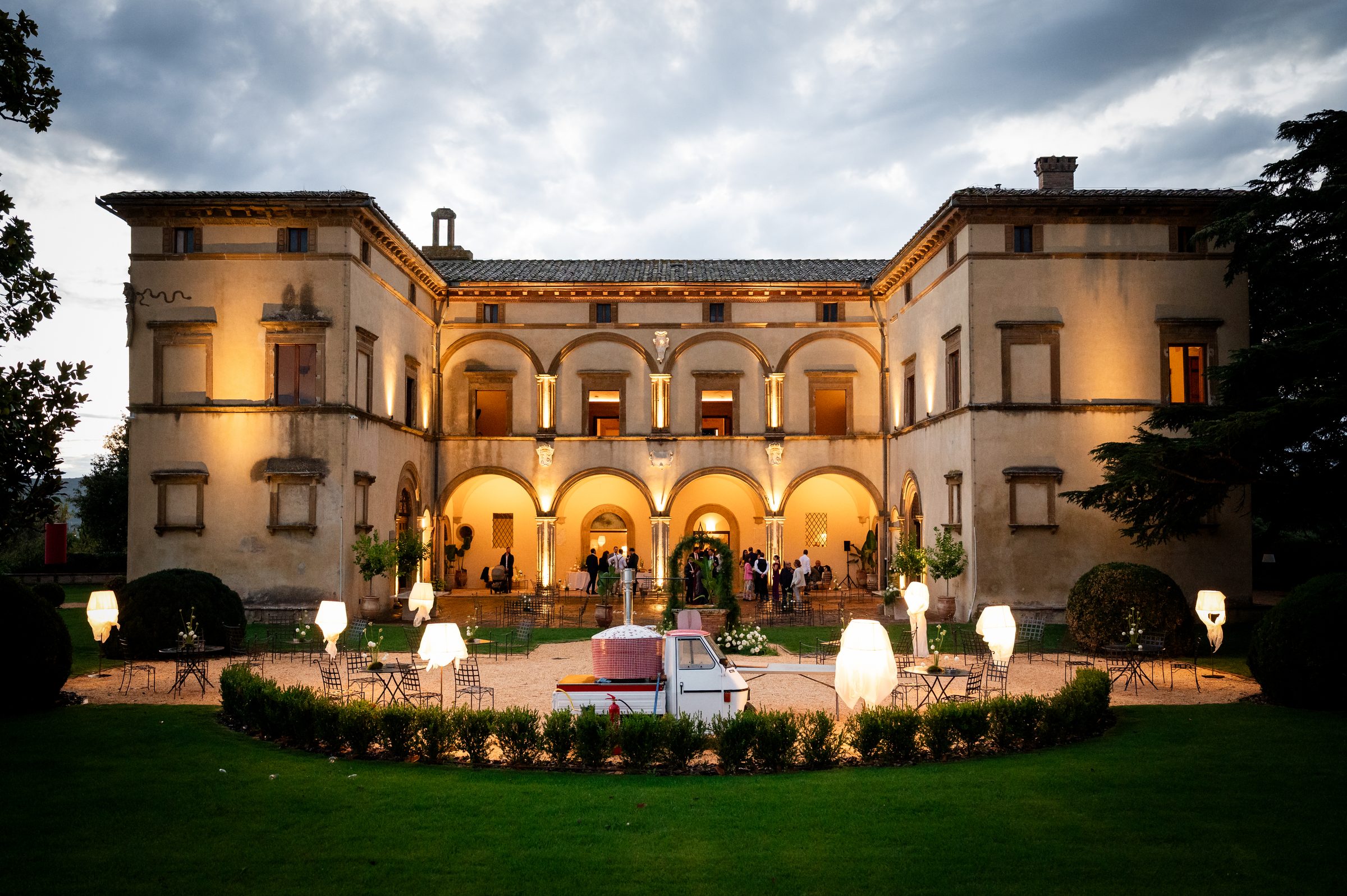 Volte Alte di sera durante un matrimonio: la facciata illuminata e la festa sul prato